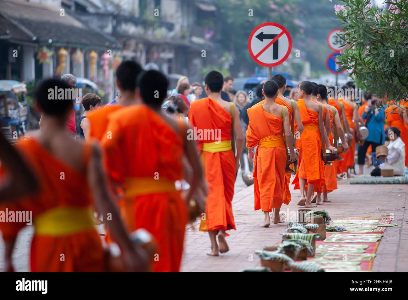 Les touristes prennent des photos de moines bouddhistes avec des cérémonies de remise d'alms bouddhistes dans la rue le matin. Luang Prabang, Laos. Banque D'Images