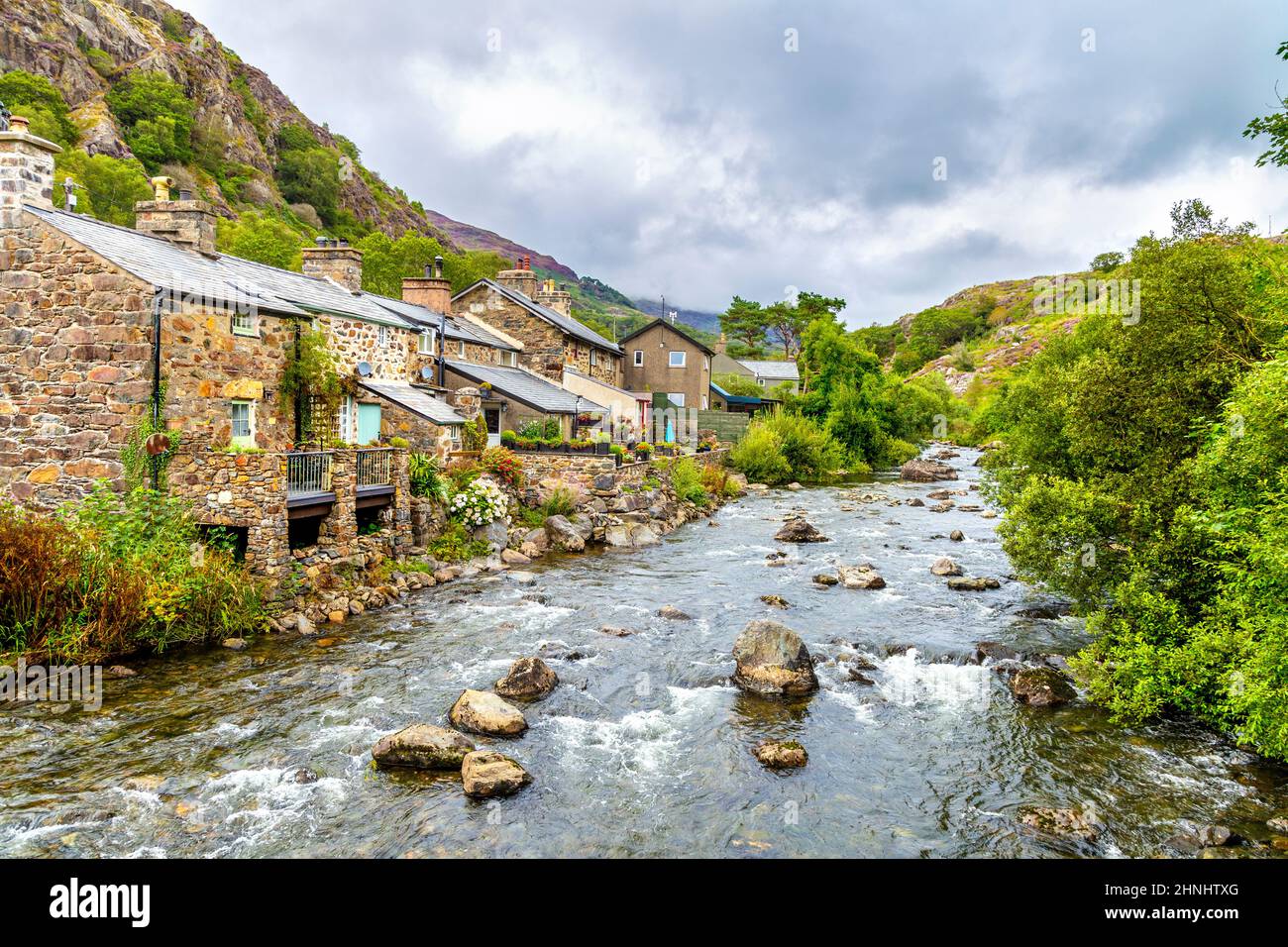 Charmants cottages en pierre le long de la rivière Colwyn au village de Beddgelert à Gwynedd, parc national de Snowdonia, pays de Galles, Royaume-Uni Banque D'Images