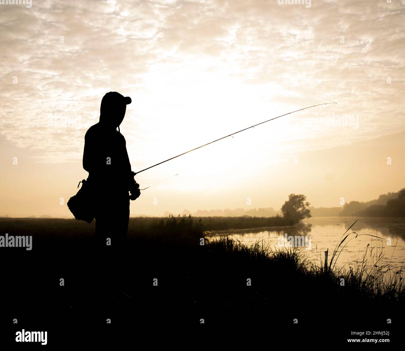 Magnifique silhouette de pêcheur actif passe-temps ombre sur le paysage de lever de soleil Banque D'Images