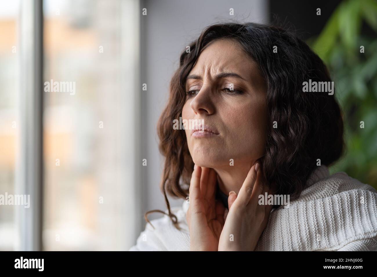 Pharyngite.Une femme malade malheureuse souffrant de toucher le cou, une femme malade ayant des douleurs de gorge extrêmes Banque D'Images