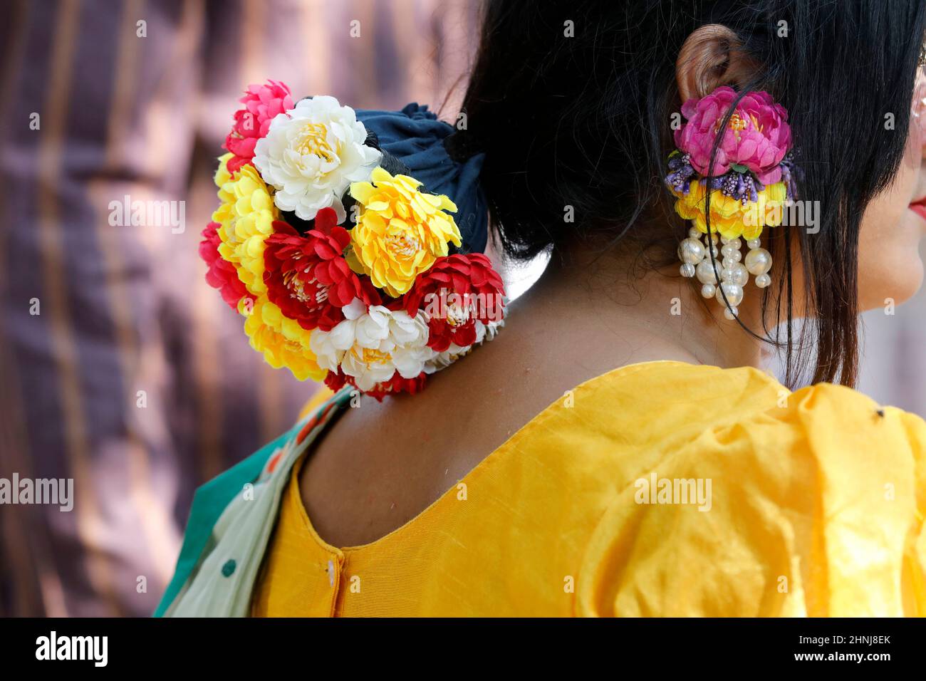 Dhaka, Bangladesh - 14 février 2022 : une fille bangladaise se promenant dans le parc avec des fleurs de couleur printanière sur ses cheveux. Banque D'Images