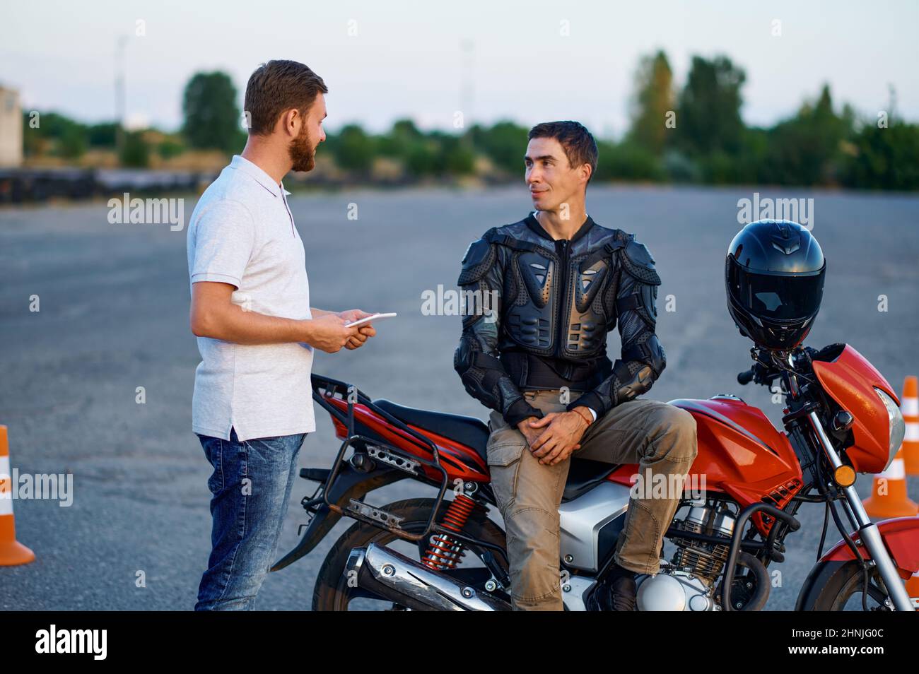Étudiant parlant avec un instructeur, une école de moto Banque D'Images