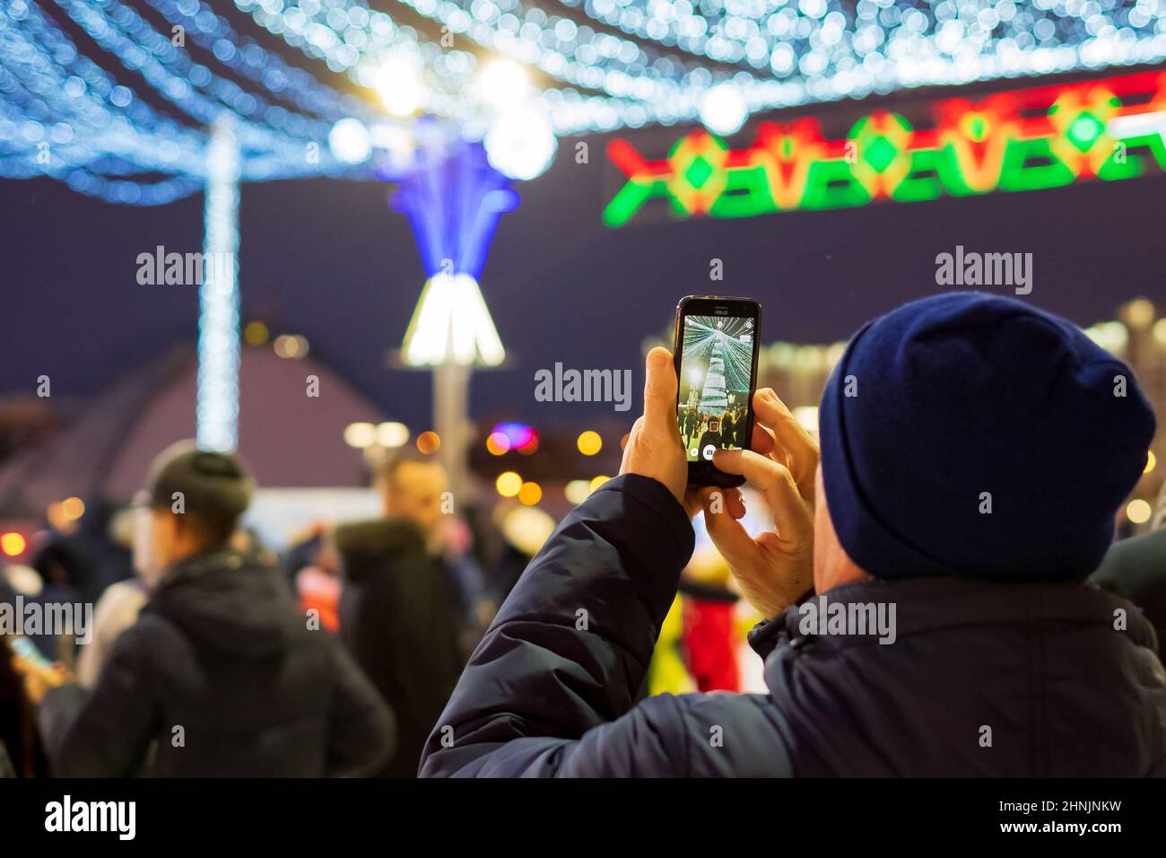 Un homme prend des photos d'un arbre de Noël Banque D'Images