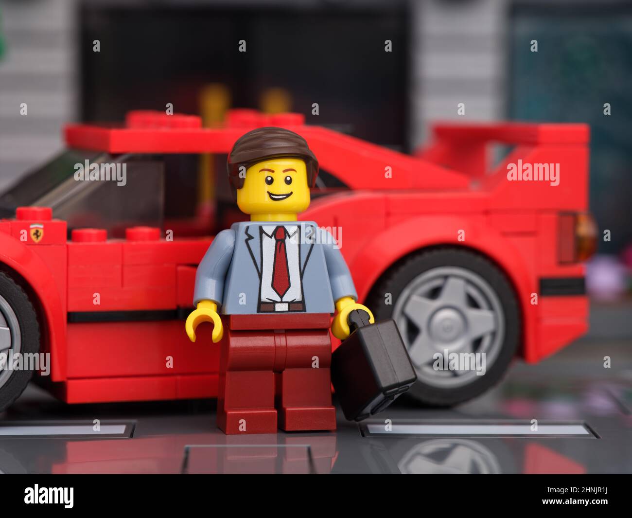 Tambov, Fédération de Russie - 13 février 2022 Une figurine d'homme d'affaires Lego debout devant sa voiture Lego Ferrari F40. Banque D'Images