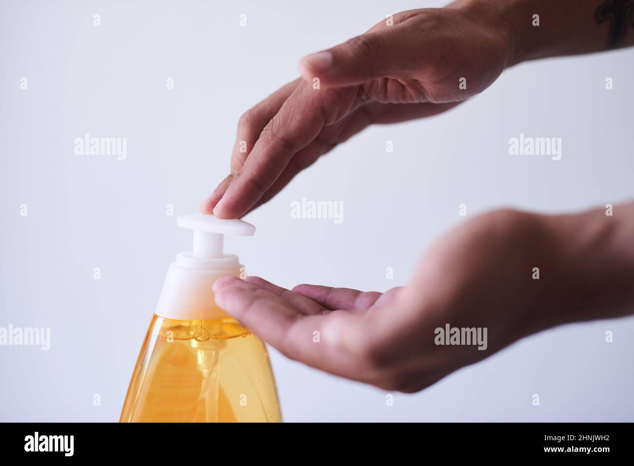 Un gros plan des mains distribuant du savon sur fond blanc Banque D'Images
