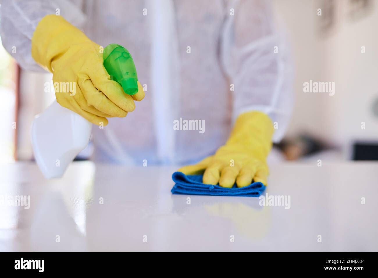 Un professionnel du nettoyage vaporise de l'assainisseur sur un comptoir de cuisine Banque D'Images