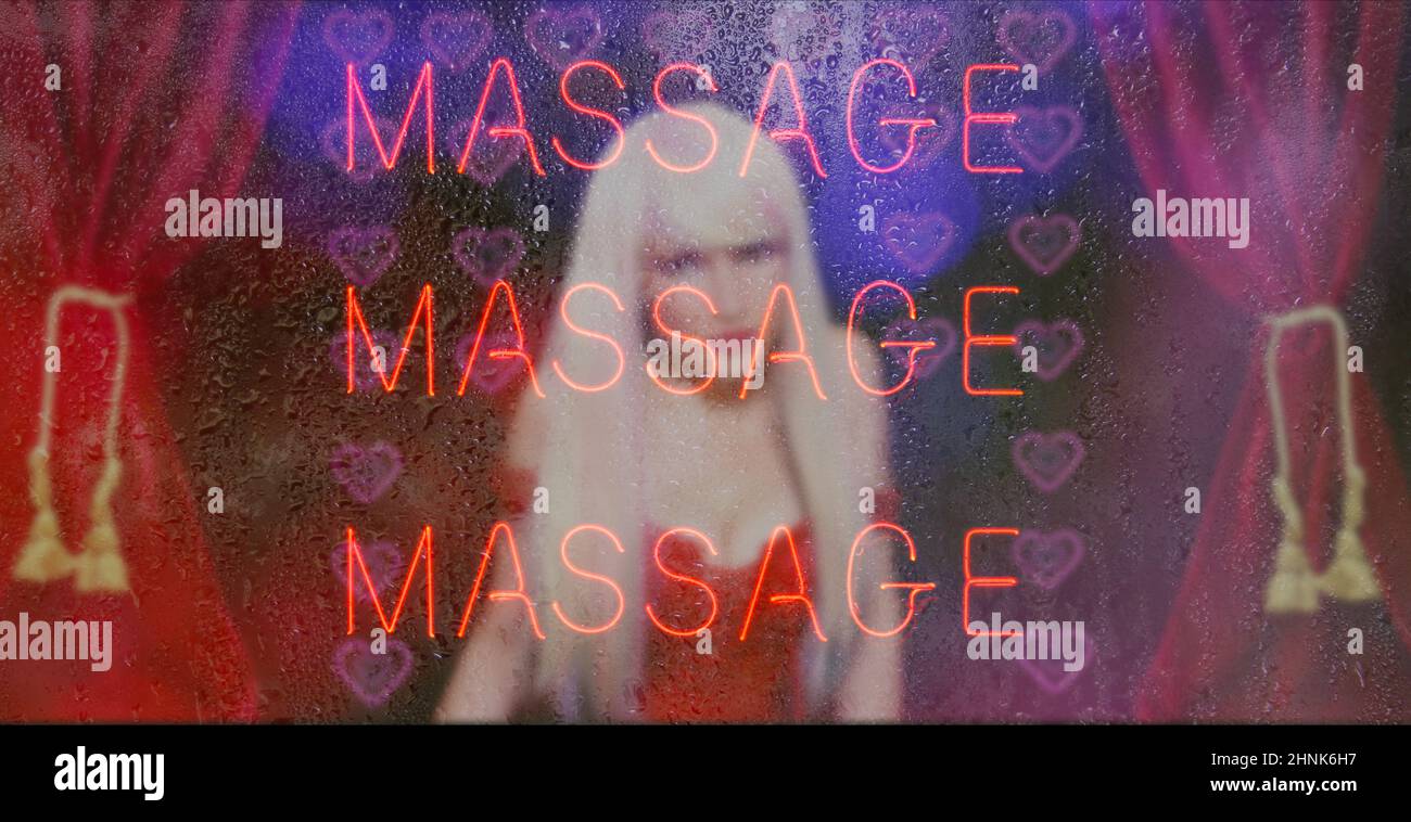 Signe de massage au néon avec la femme Sexy en arrière-plan. Fenêtre pluvieuse Banque D'Images