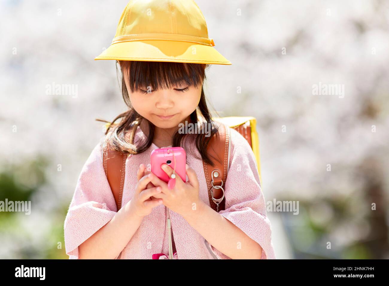 École primaire japonaise fille à l'exploitation D'Un téléphone portable pour les enfants Banque D'Images