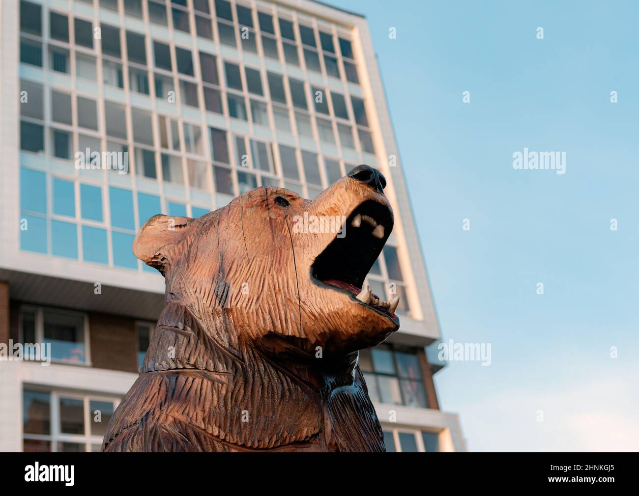 tête d'ours en bois sur fond de maison d'appartement Banque D'Images