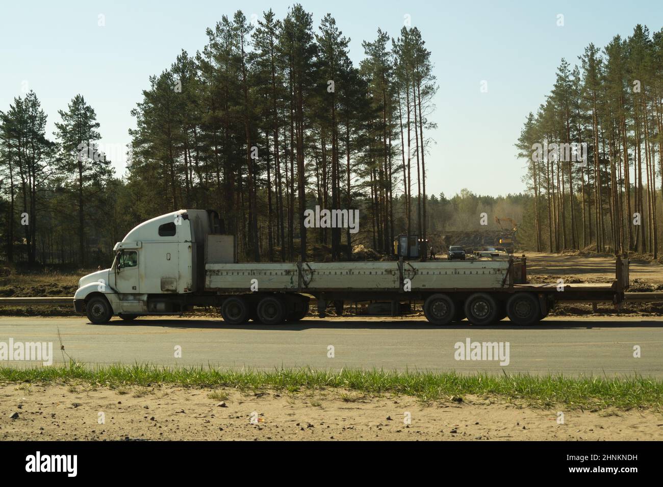 Gros camion sur le bord de la route près de la forêt. Camion blanc sur une route Banque D'Images