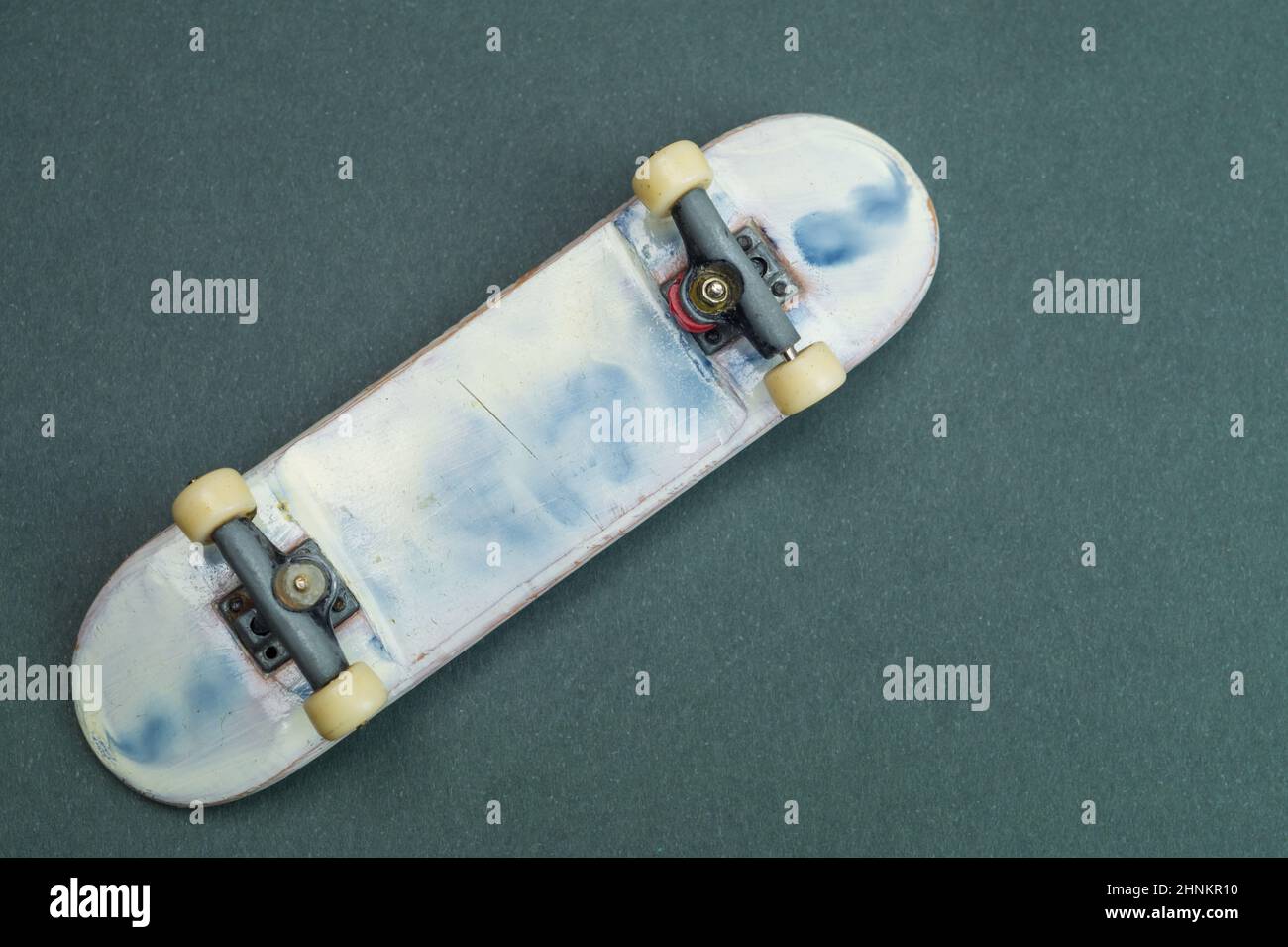 Petit skateboard sur fond de couleur. Petit skate pour les doigts. Fingerboard gros plan. Concept de loisirs à la maison Banque D'Images