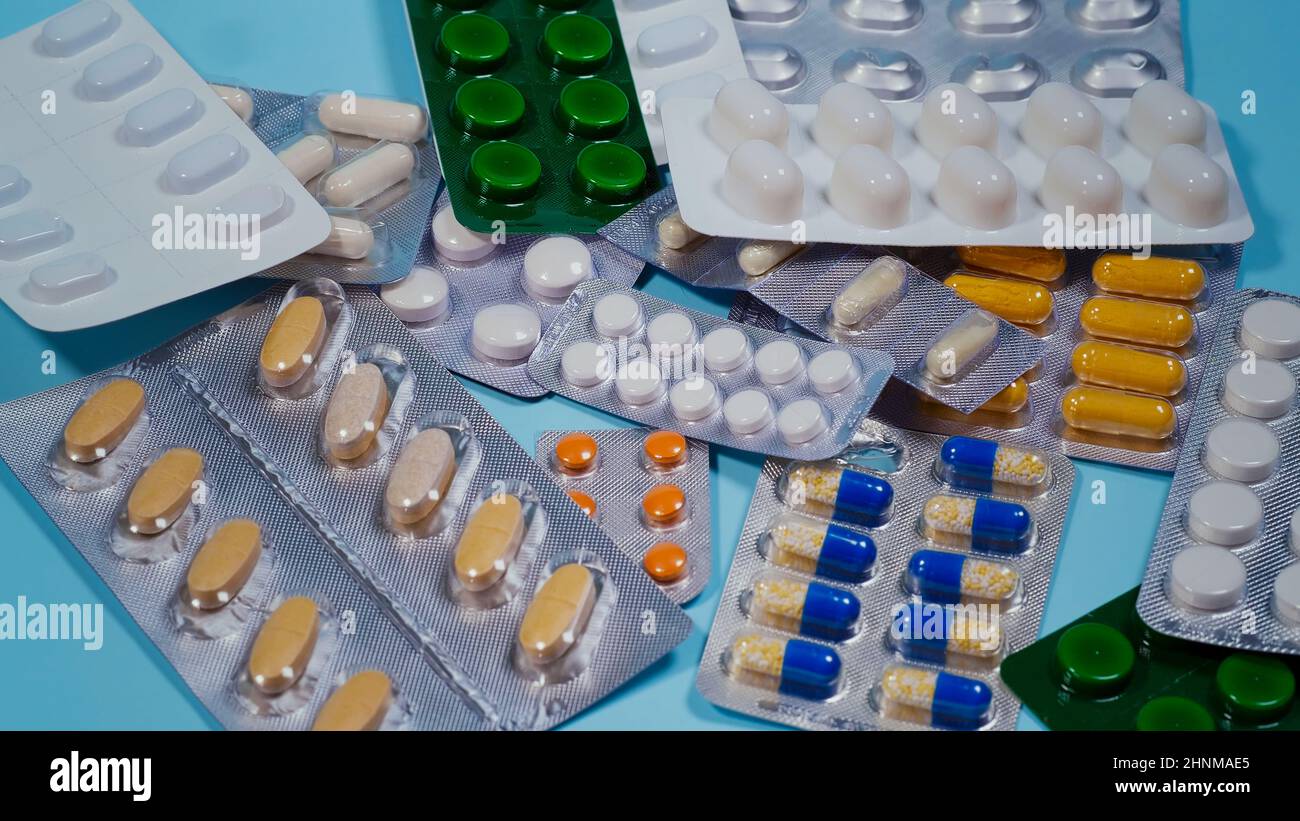 Pile de pilules en blister sur fond bleu. Banque D'Images