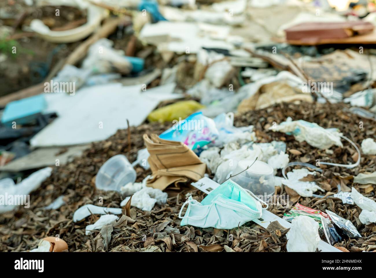 Le masque utilisé doit être mis au rebut dans les ordures ménagères.Élimination des déchets médicaux avec gestion non hygiénique.Déchets contaminés dans la communauté.Masque facial jetable avec contour d'oreille, déchets sur le sol.Impact du coronavirus Banque D'Images