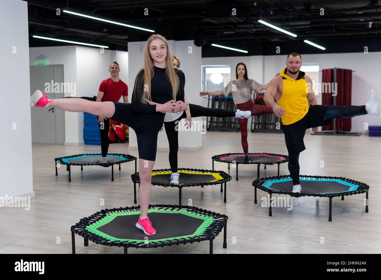 Groupe de femmes et d'hommes sur un trampoline de sport, entraînement de  fitness, vie saine - un concept trampoline groupe batut fille en bonne santé,  pour le style de vie athlétique Photo