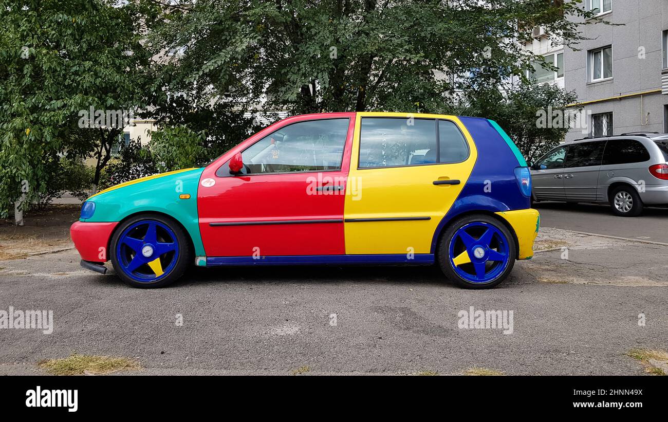 Ukraine, Kiev - 27 mars 2020: Volkswagen Golf 4 modèle avec un hayon avec des parties de carrosserie multicolores. Voiture amusante et lumineuse en rouge, bleu, jaune. Voiture peinte dans différentes couleurs Banque D'Images