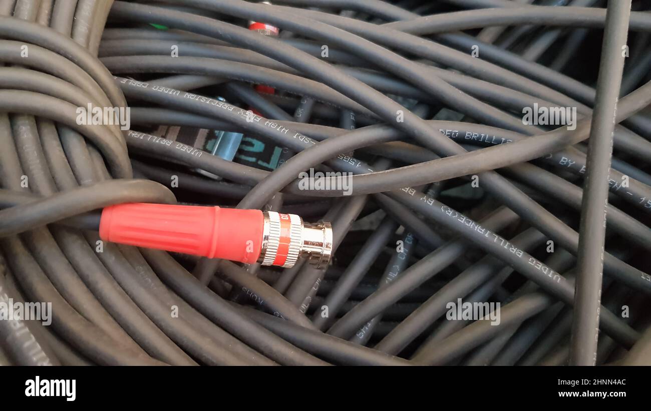 Un rouleau de câble noir avec une fiche rouge. Banque D'Images