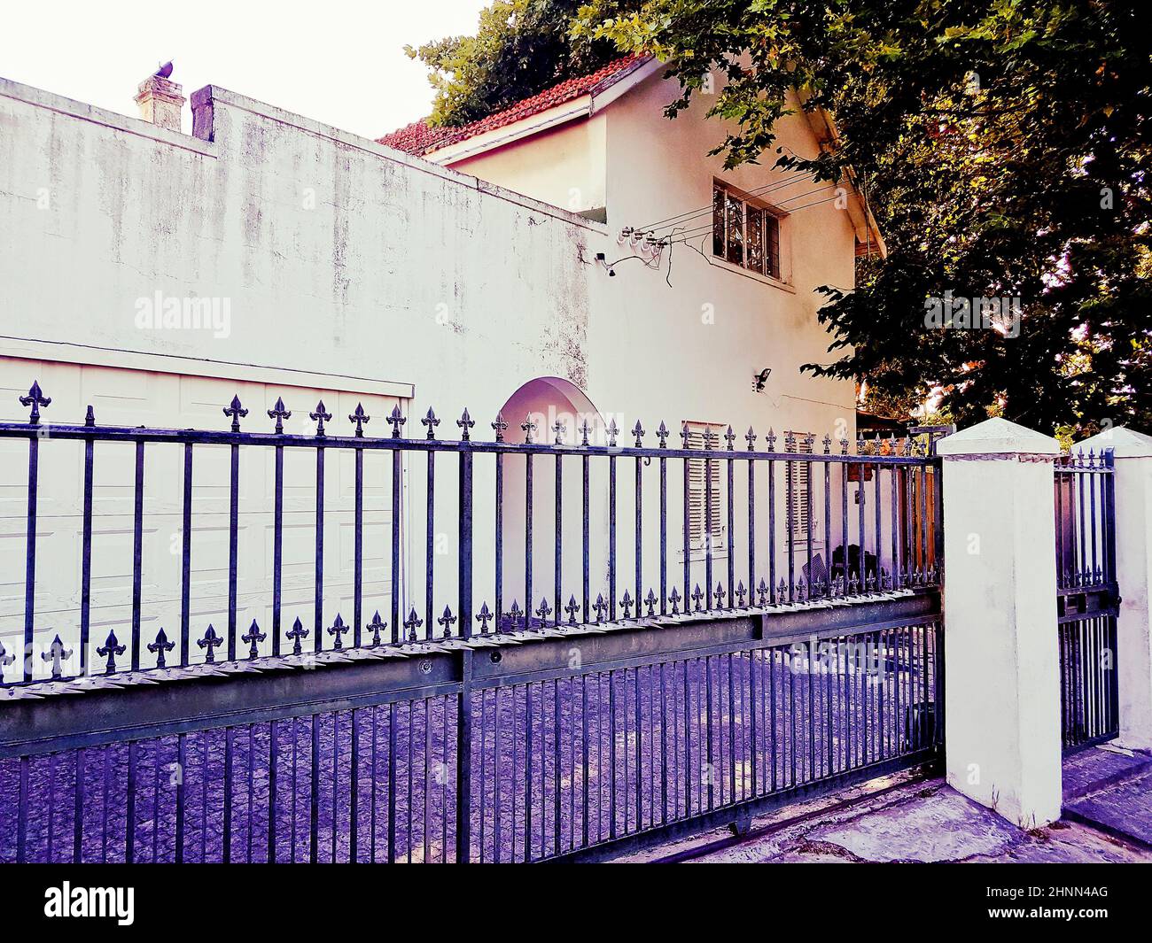 Ancien bâtiment blanc et violet nostalgique derrière une clôture, le Cap. Banque D'Images