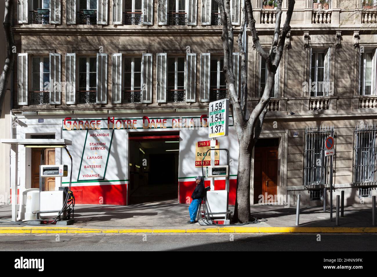 Préposé à la station-service attendant à sa petite station pour les clients à Marseille, France en chaleur estivale Banque D'Images