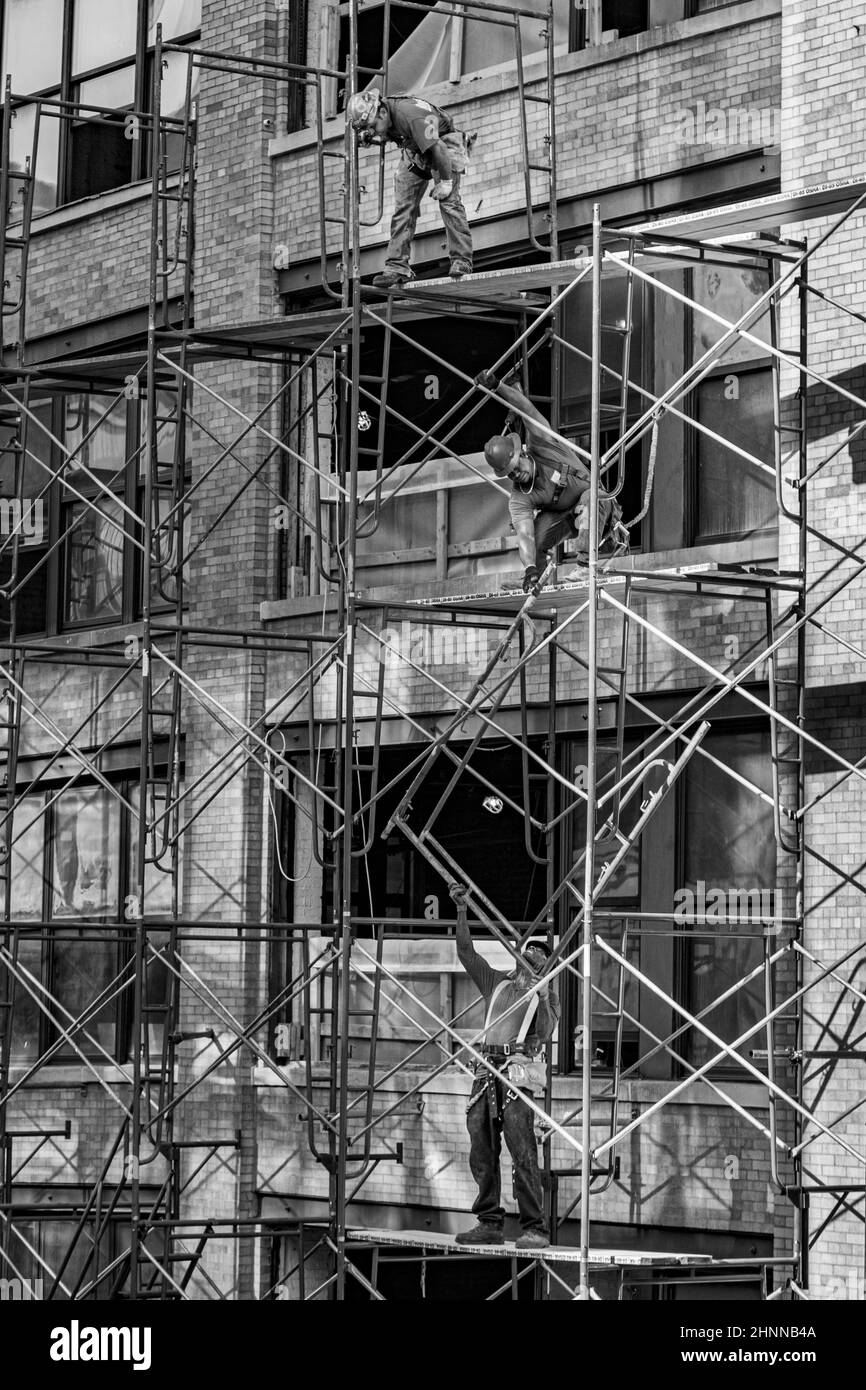 un travailleur sur un chantier de construction travaille sur un échafaudage dans un ancien bâtiment typique de new york Banque D'Images