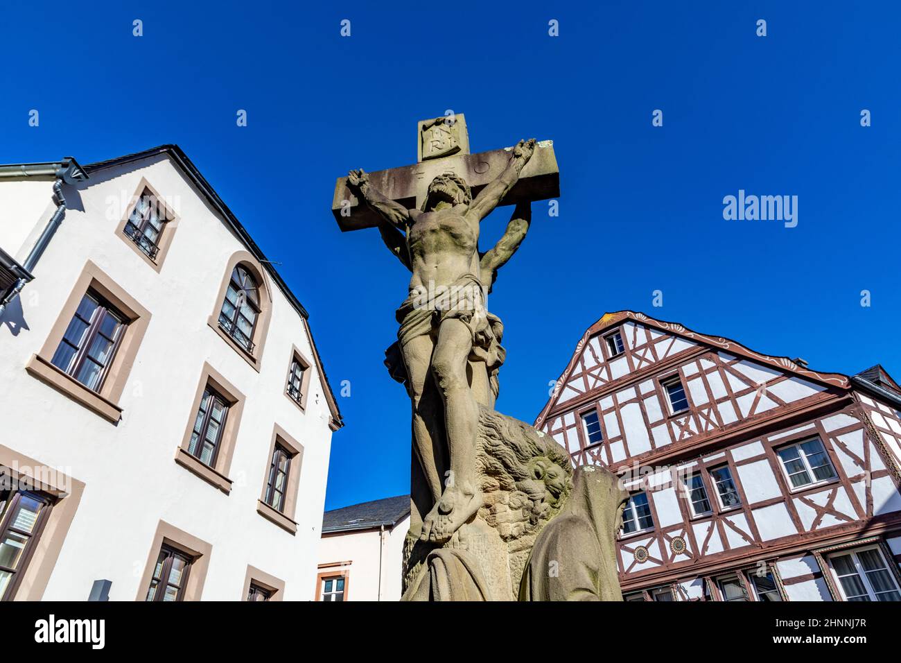 Bernkastel-Kues, Allemagne - février 21,2021 : maisons à colombages à Bernkastel-Kues, Allemagne avec statue de jésus sous ciel bleu. Banque D'Images