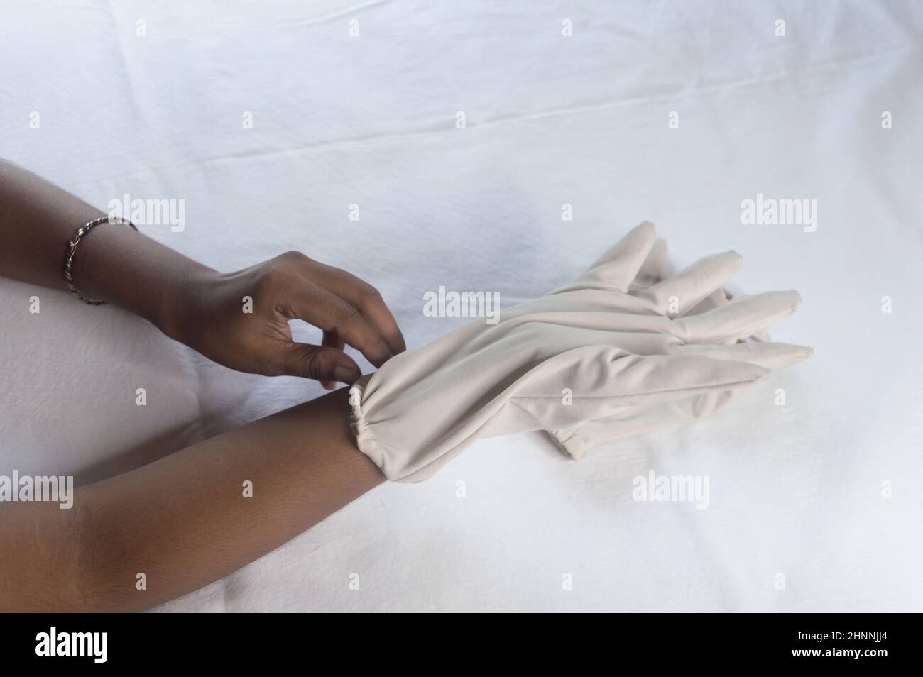 Main porter des gants jetables sur fond blanc.Vue grand angle.Gros plan.Utilisation et protection de l'hygiène des mains pour réduire le risque de SPR Banque D'Images