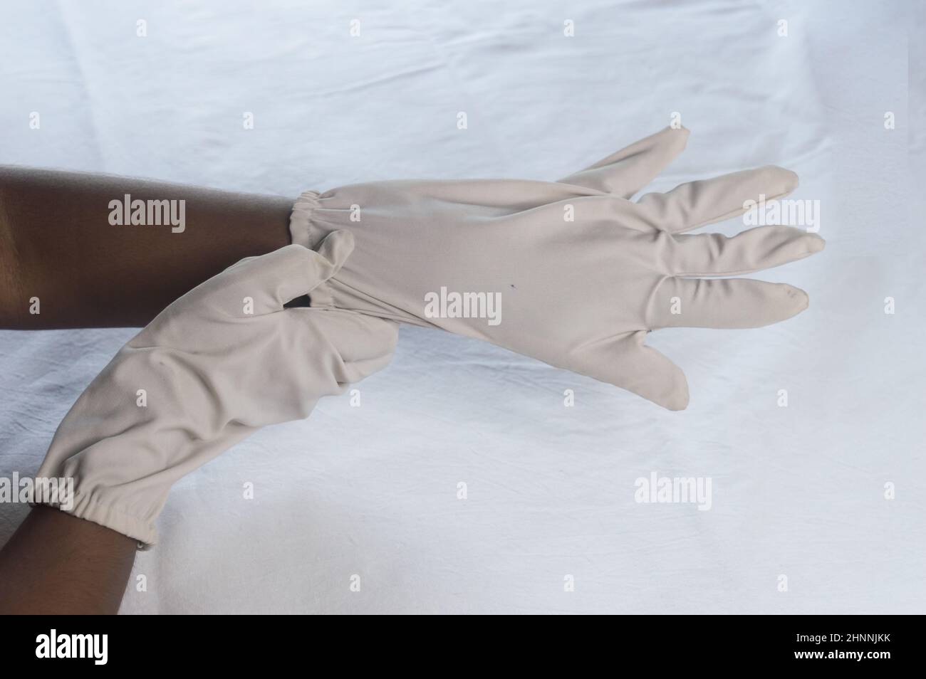 Main porter des gants jetables sur fond blanc.Vue grand angle.Gros plan.Utilisation et protection de l'hygiène des mains pour réduire le risque de SPR Banque D'Images