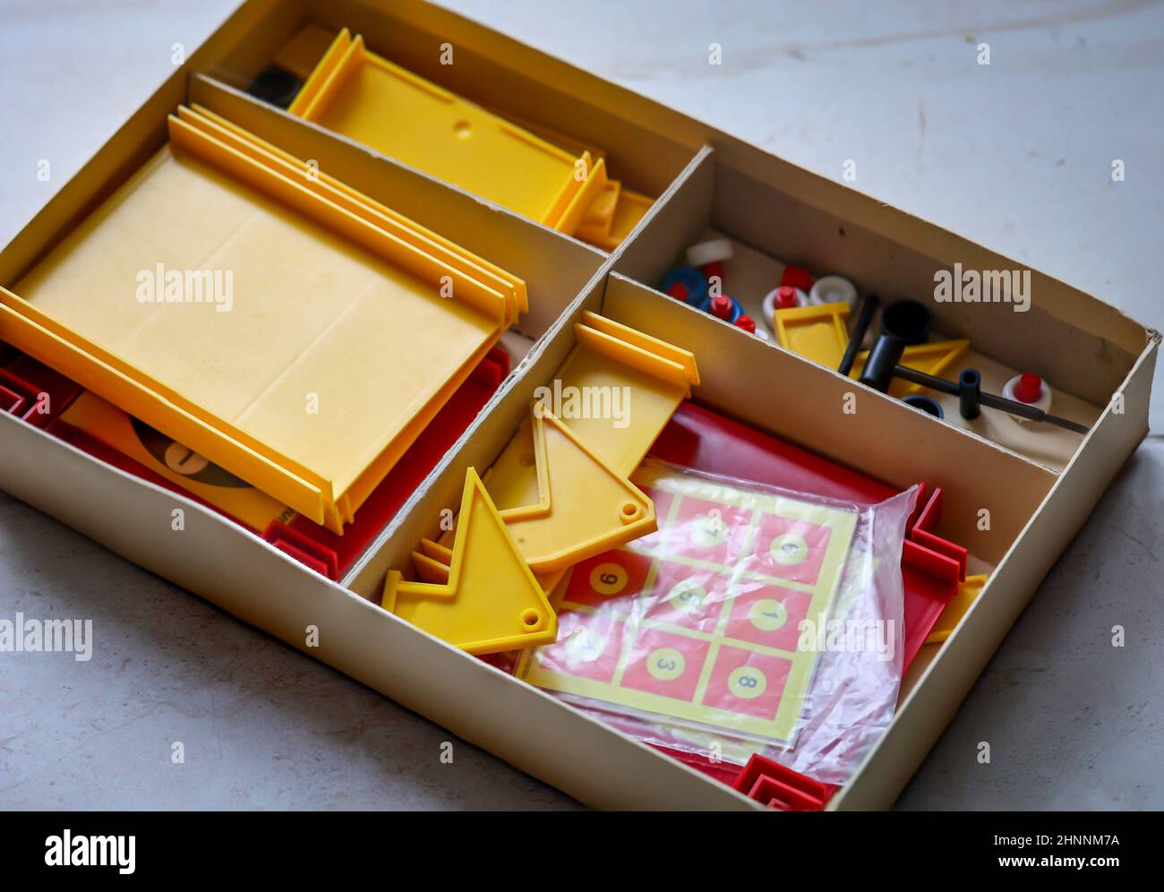 Une boîte avec des jouets en plastique comme son contenu. Un jouet shuffle de GDR Times dans une boîte en carton. Banque D'Images