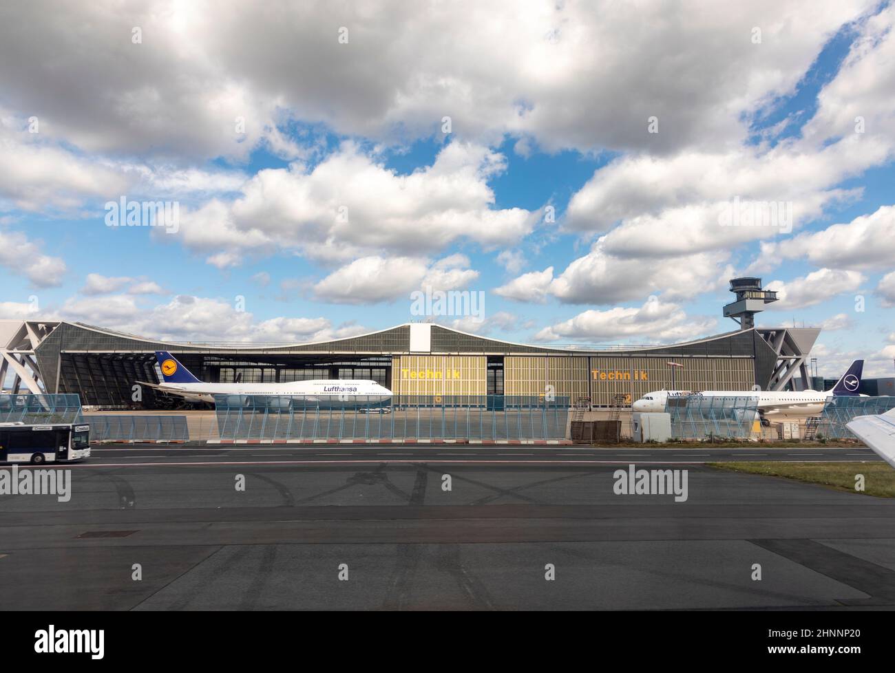 salle de maintenance lufthansa en construction papillon avec parking Boeing 747 et un Airbus devant et passage de l'équipage de bus Banque D'Images