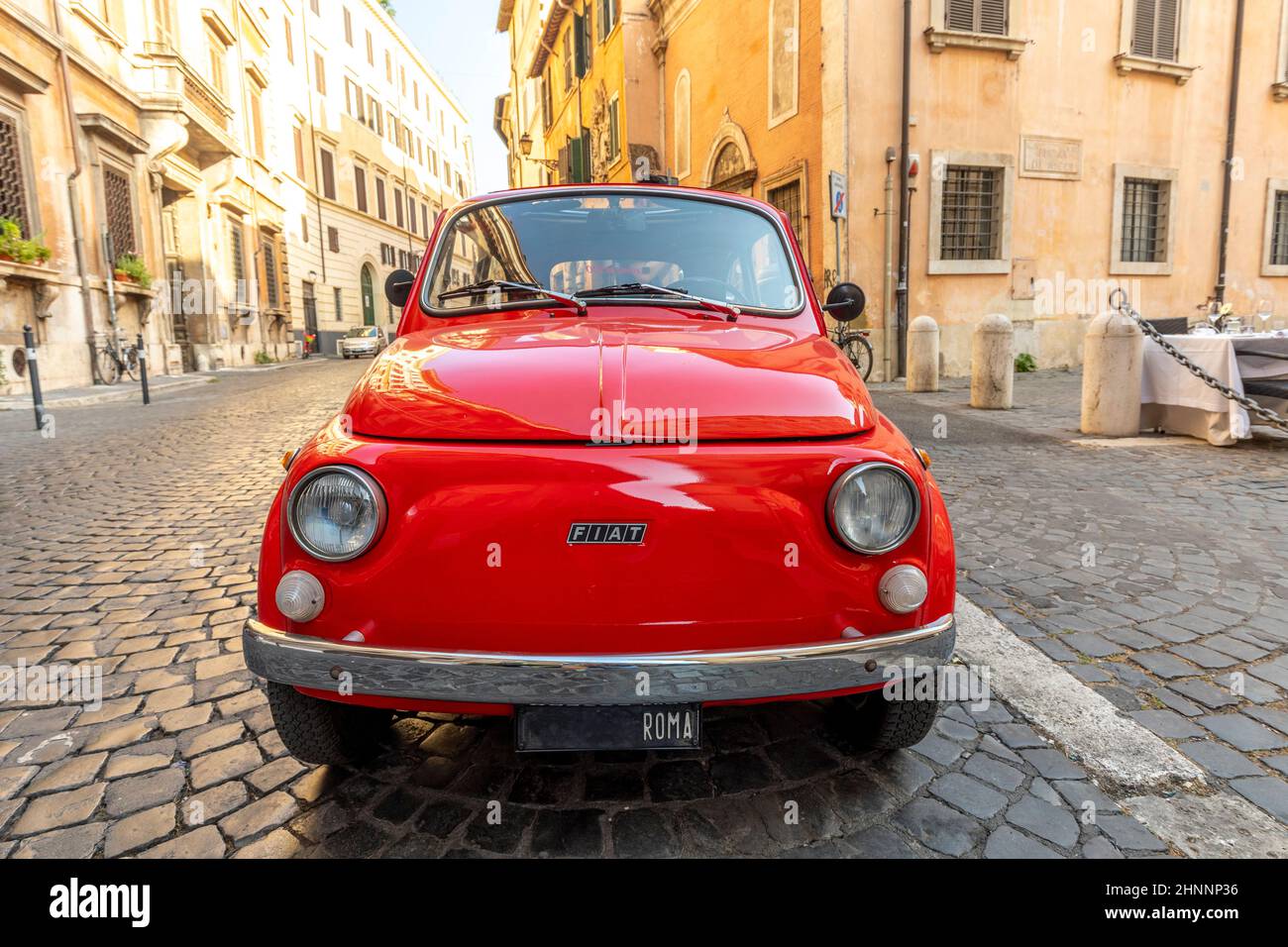 Fiat 500 d'époque garée à côté d'un restaurant à Rome dans le centre-ville au quartier de Regla sur la rue pavée. La célèbre marque automobile italienne fondée en 1899. Banque D'Images