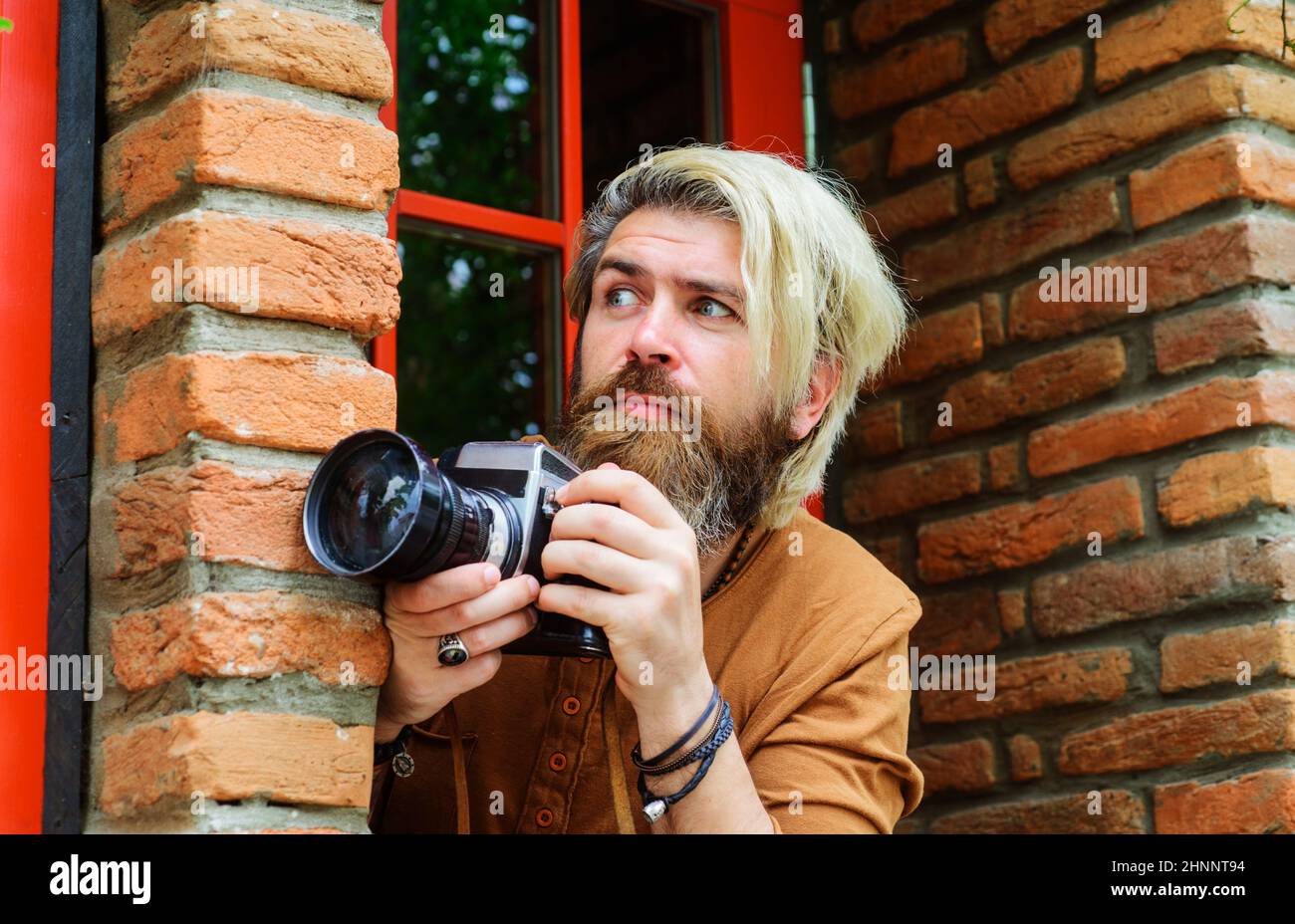 Paparazzi prendre des photos avec photocamera. Homme barbu avec appareil photo. Photojournaliste. Détective Banque D'Images