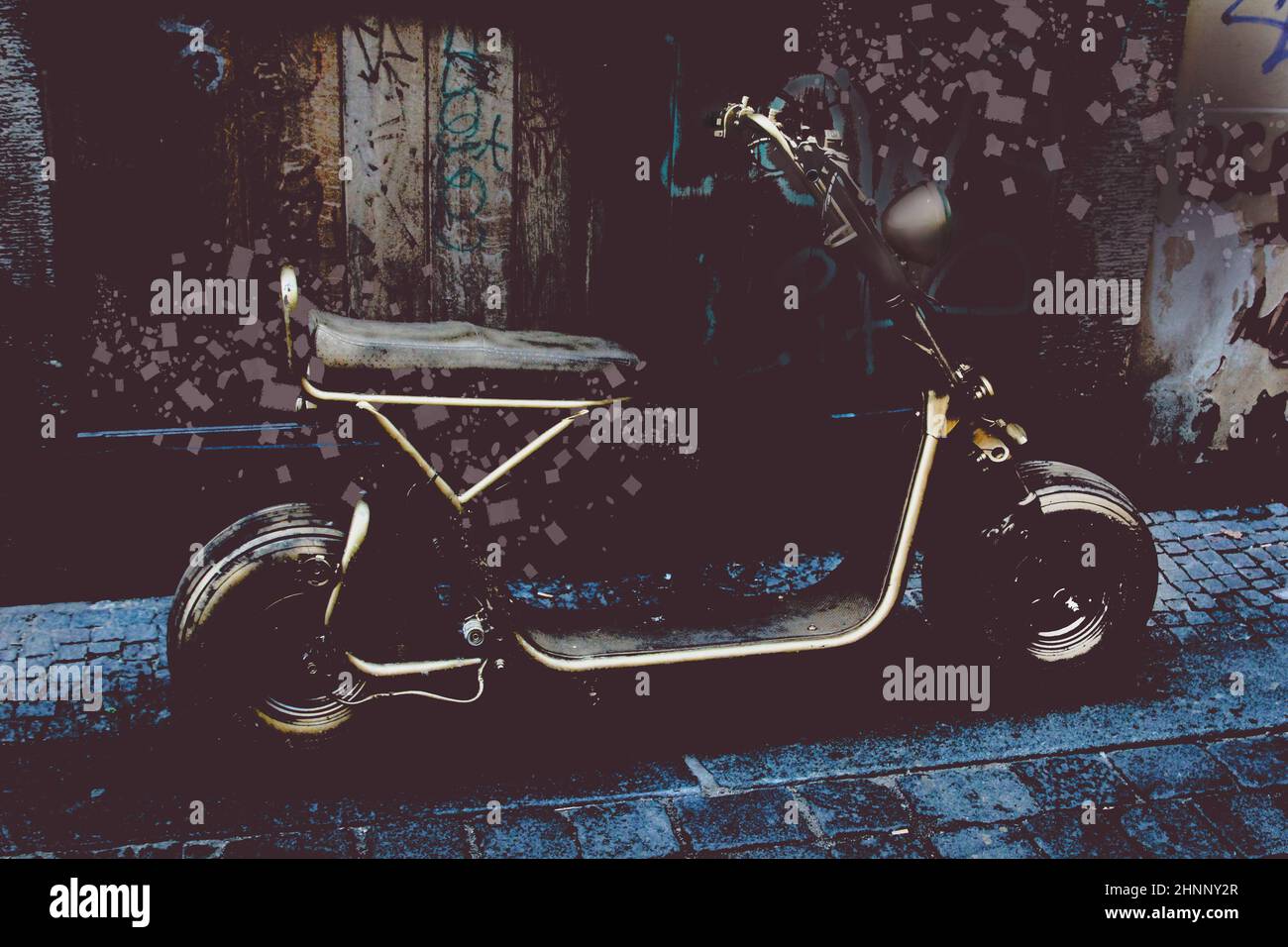 Un véhicule de style scooter mis en avant, stationné contre un mur. Banque D'Images