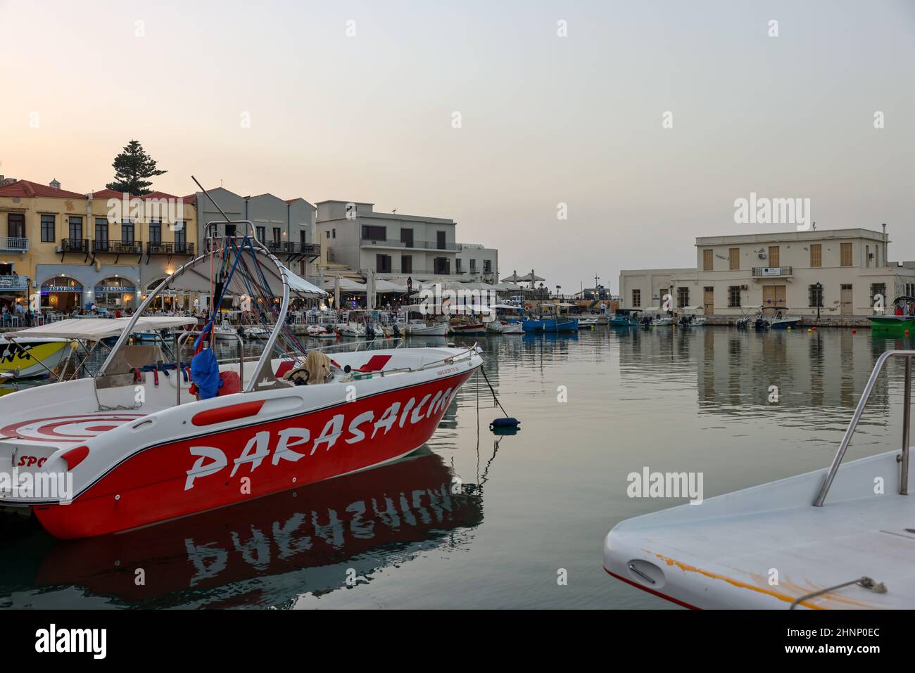 Restaurants au bord de l'eau en début de soirée, lumière au vieux port vénitien de Rethymnon. Crète, Grèce Banque D'Images
