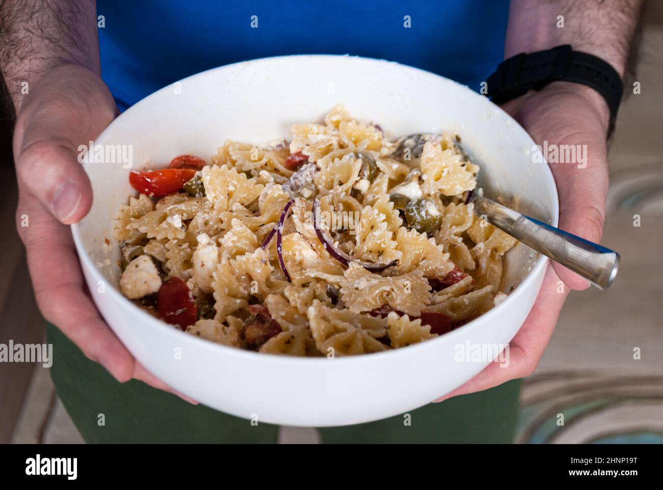 Gros plan les hommes tiennent un bol avec de la salade de pâtes Banque D'Images