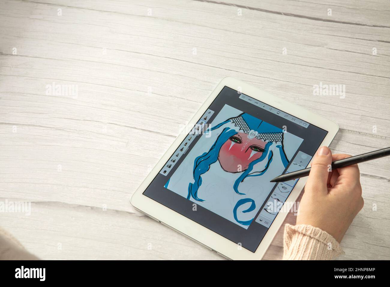 Jeune créateur tenant le stylet dessin à l'écran de tablette numérique sur un bureau en bois avec espace de copie, vue de dessus d'art numérique moderne Banque D'Images