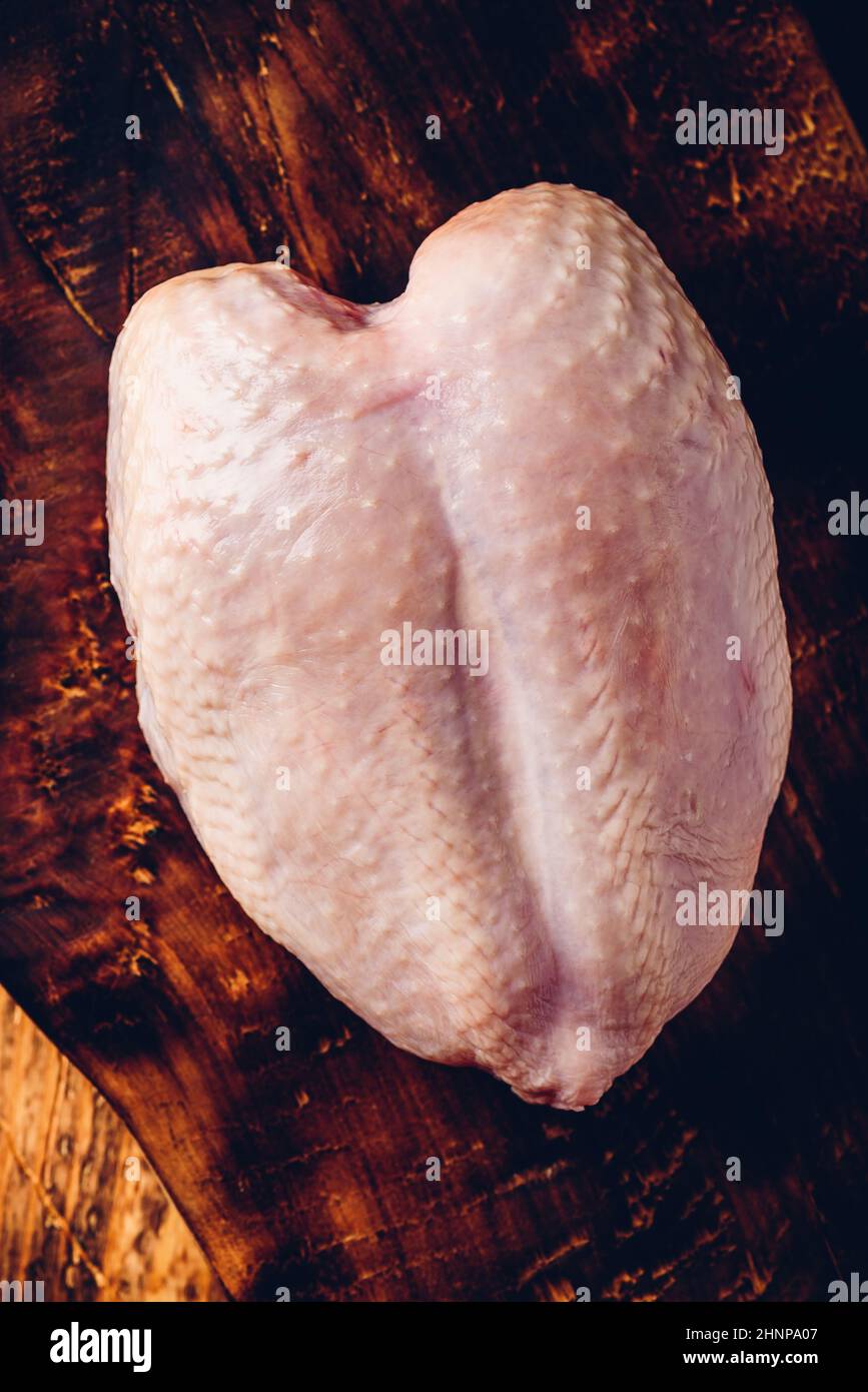 Poitrine de poulet cru rustique sur planche à découper Banque D'Images