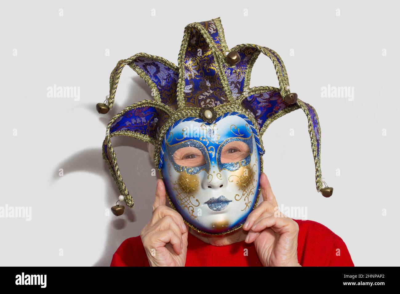 Femme âgée avec masque de carnaval sur son visage Banque D'Images