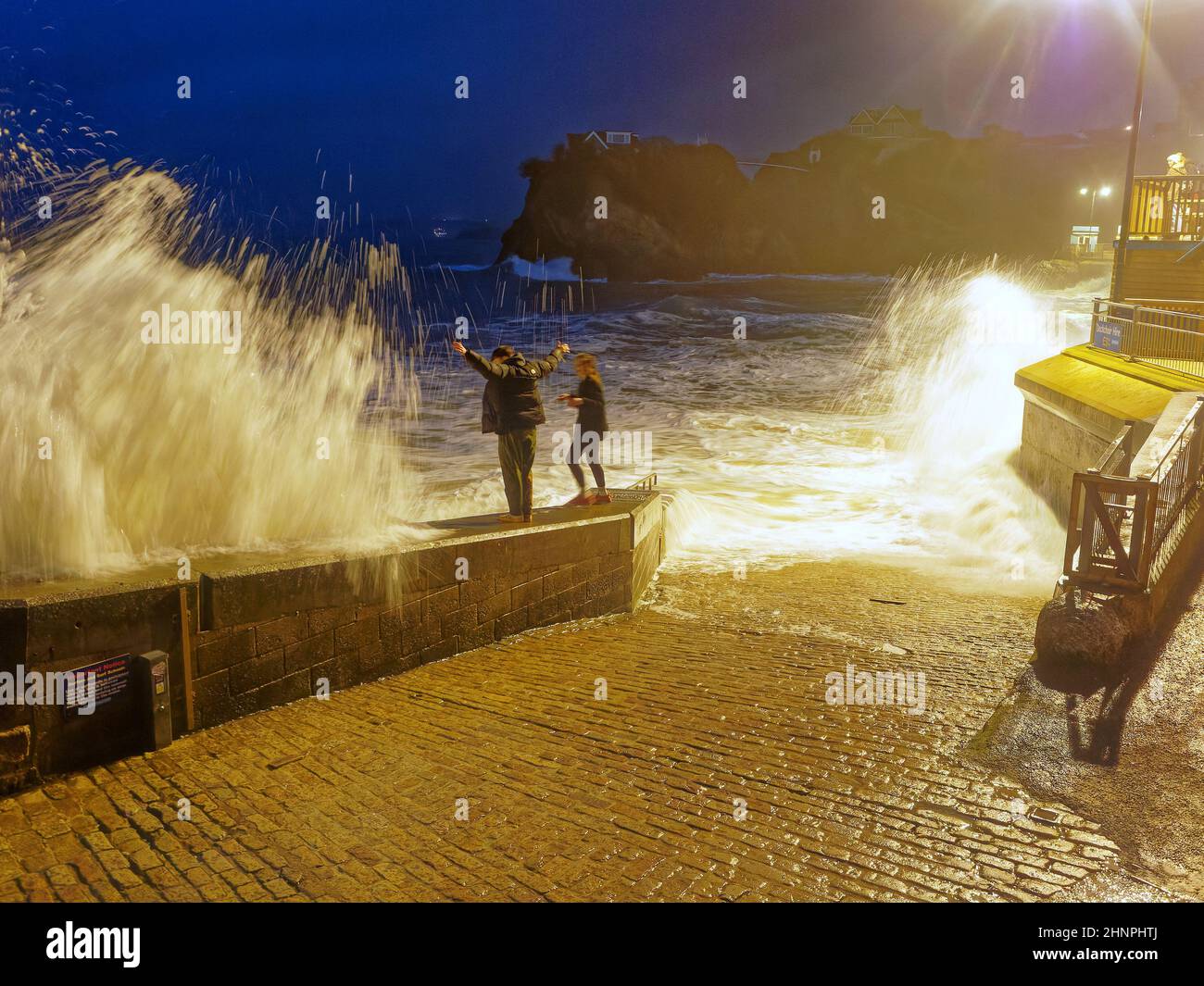 Cornwall, Royaume-Uni, Newquay. 17th février 2022. La noyade est proche des jeunes épris de frisson femelles tandis que les immenses vagues de tempête d'Eunice déferlent les touristes imprudents du mur de la mer à la plage de Towan à Newquay, au Royaume-Uni, et dans l'océan. Le lavage de fond et le remorquage féroces ont rapidement éloigné la femme du rivage, heureusement elle a réussi à retrouver la sécurité avec l'aide des spectateurs. Les gardes-côtes ont demandé aux gens d'éviter les côtes de Cornwall pendant la période d'alerte rouge du bureau du met. Robert Taylor Alamy Live News Banque D'Images