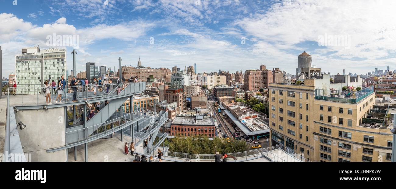 Les gens regardent le centre-ville de Manhattan, New York depuis la fin de la piste High Line depuis la plate-forme du musée Whitney Banque D'Images
