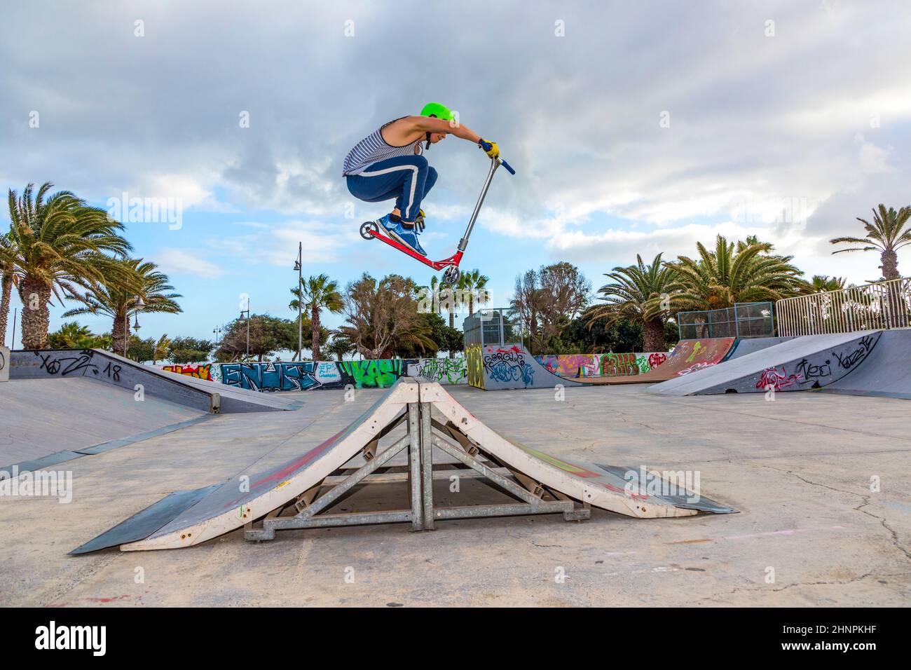 garçon sautant au skate park sur une rampe Banque D'Images