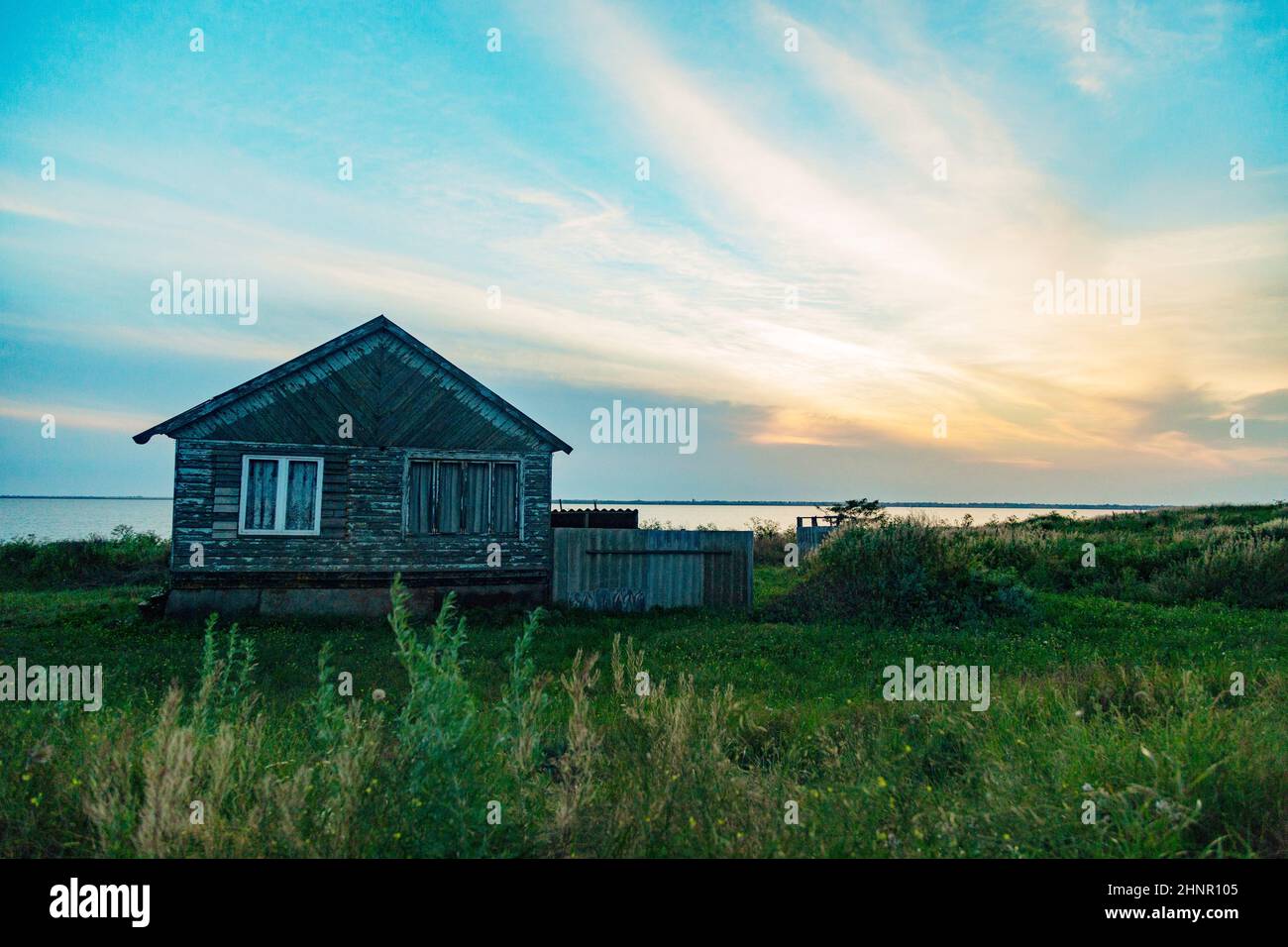 Ancienne maison en bois au bord de la mer. Paysage merveilleux avec un beau coucher de soleil Banque D'Images