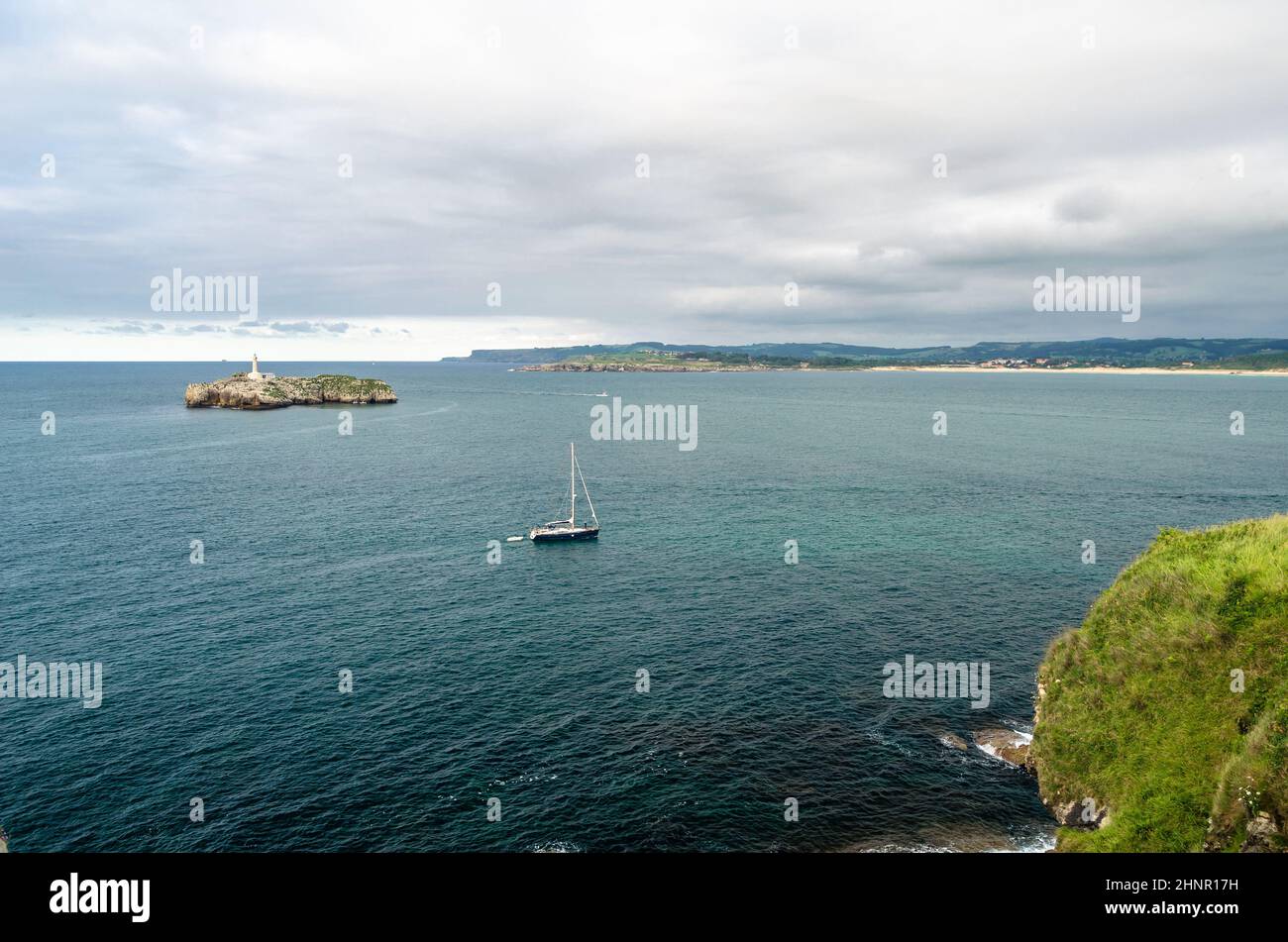 SANTANDER, ESPAGNE - 9 JUILLET 2021: Vue de la péninsule de Magdalena, Santander, Espagne, avec un petit bateau à voile et l'île de Mouro en arrière-plan avec son phare du 19th siècle Banque D'Images