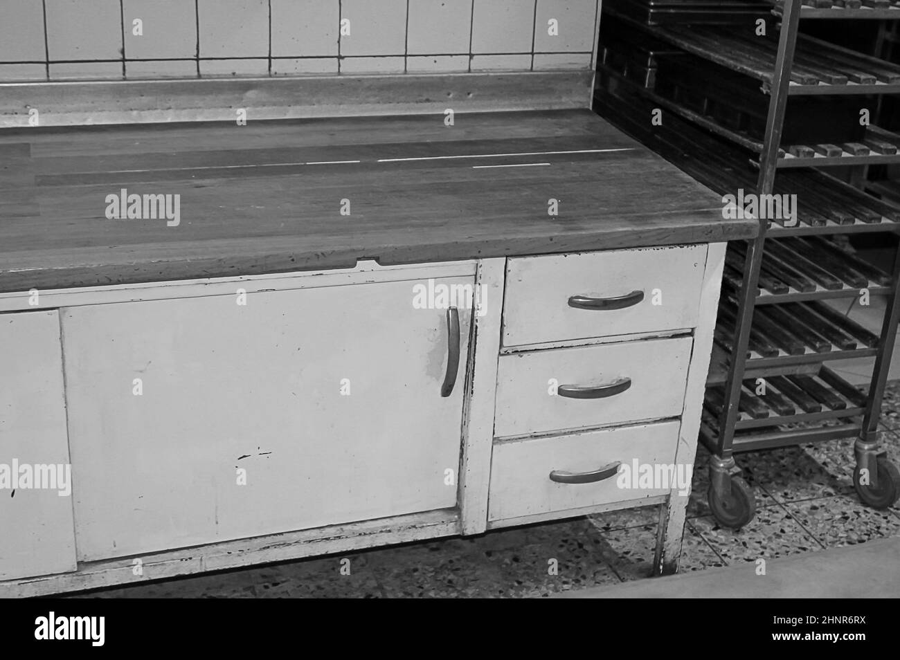 Découvrez une ancienne boulangerie, une table de travail et des compartiments de rangement pour les produits de boulangerie. Banque D'Images