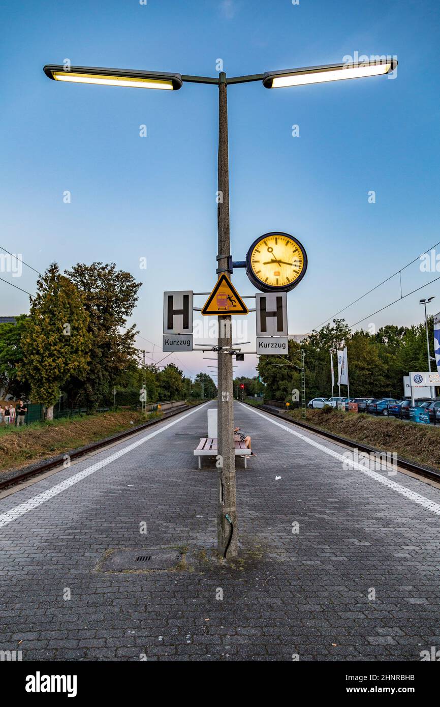les gens assis à un banc et attendent le prochain train Banque D'Images