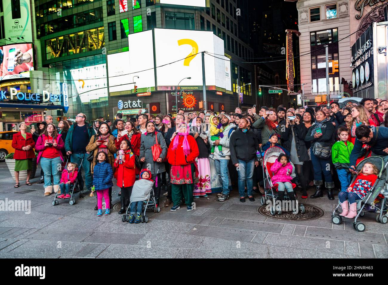 Les gens regardent l'émission de télévision publique sur un écran de Times Square la nuit Banque D'Images