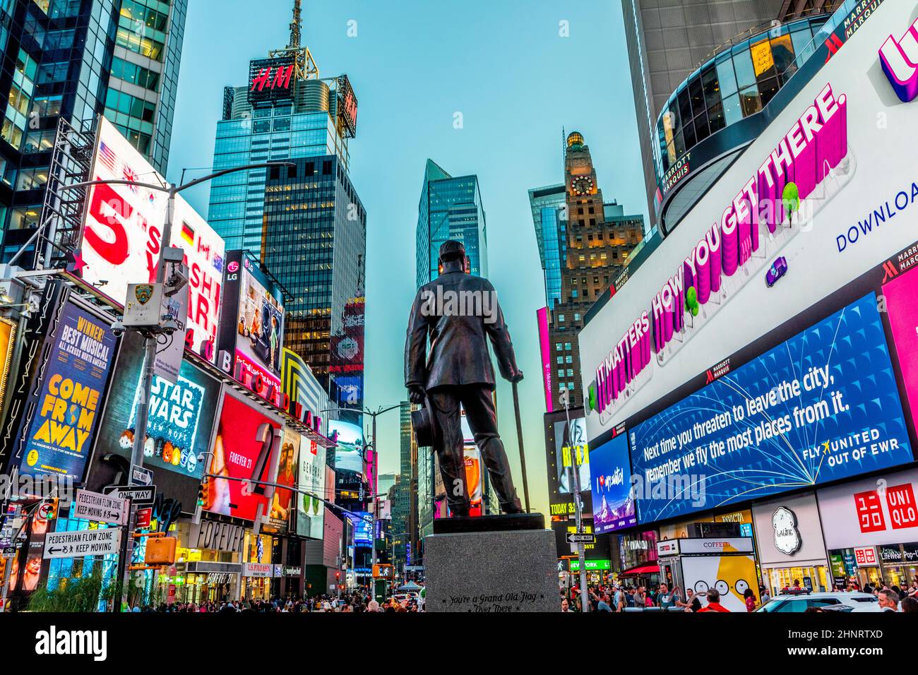 Publicité au néon des nouvelles, des marques et des théâtres à Times Square avec statue de George M. Cohan en début de matinée. Banque D'Images