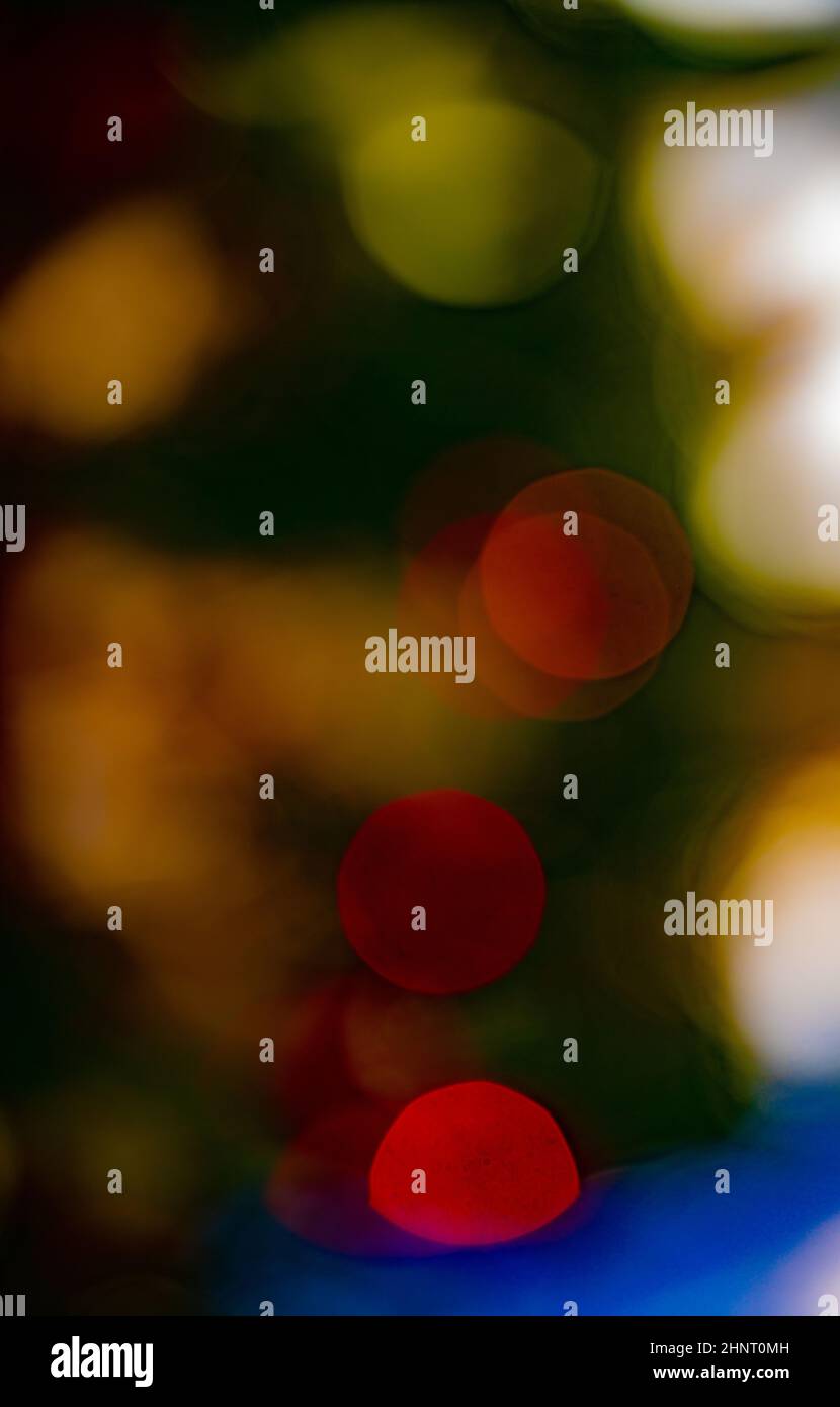Effets spéciaux de bokeh doux foyer de Noël lumières colorées dans l'arbre d'hiver vert rouge jaune et blanc bokeh cercles colorés vertical Banque D'Images