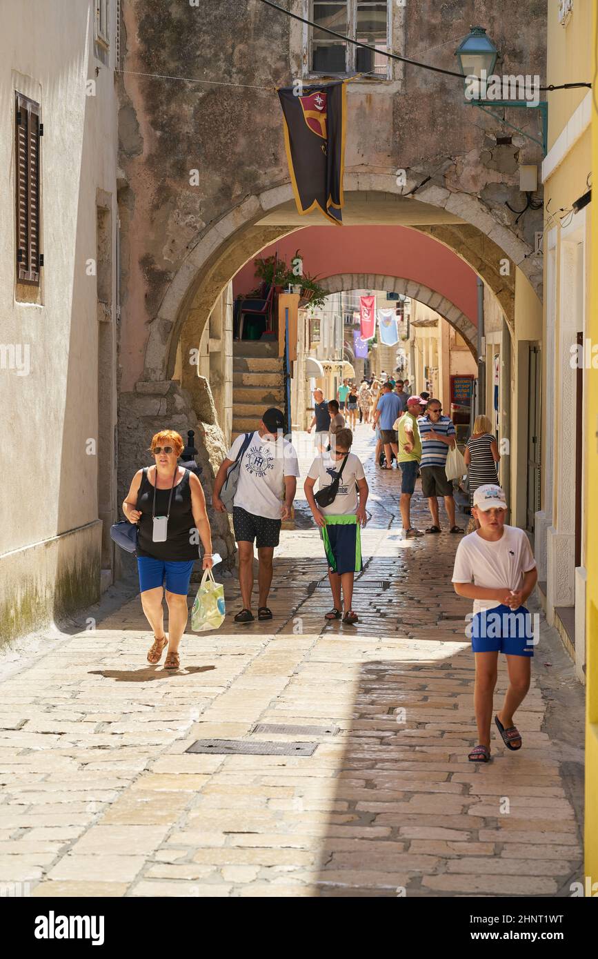 Touristes dans une ruelle dans la vieille ville de Rab sur l'île du même nom sur la mer Adriatique en Croatie Banque D'Images