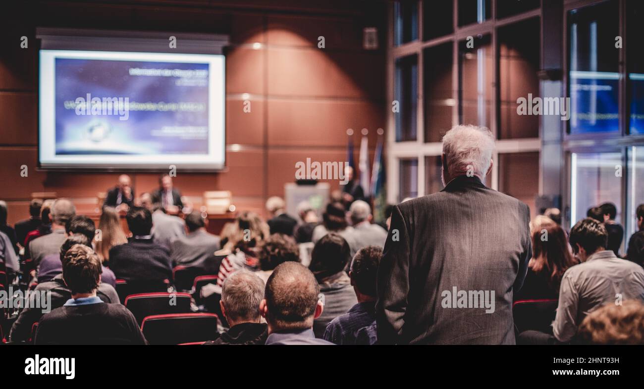 J'ai une question. Groupe de personnes en voyage d'affaires assis dans la salle de conférence. Homme d'affaires levant le bras. Conférence et présentation. Affaires et entrepreneuriat Banque D'Images