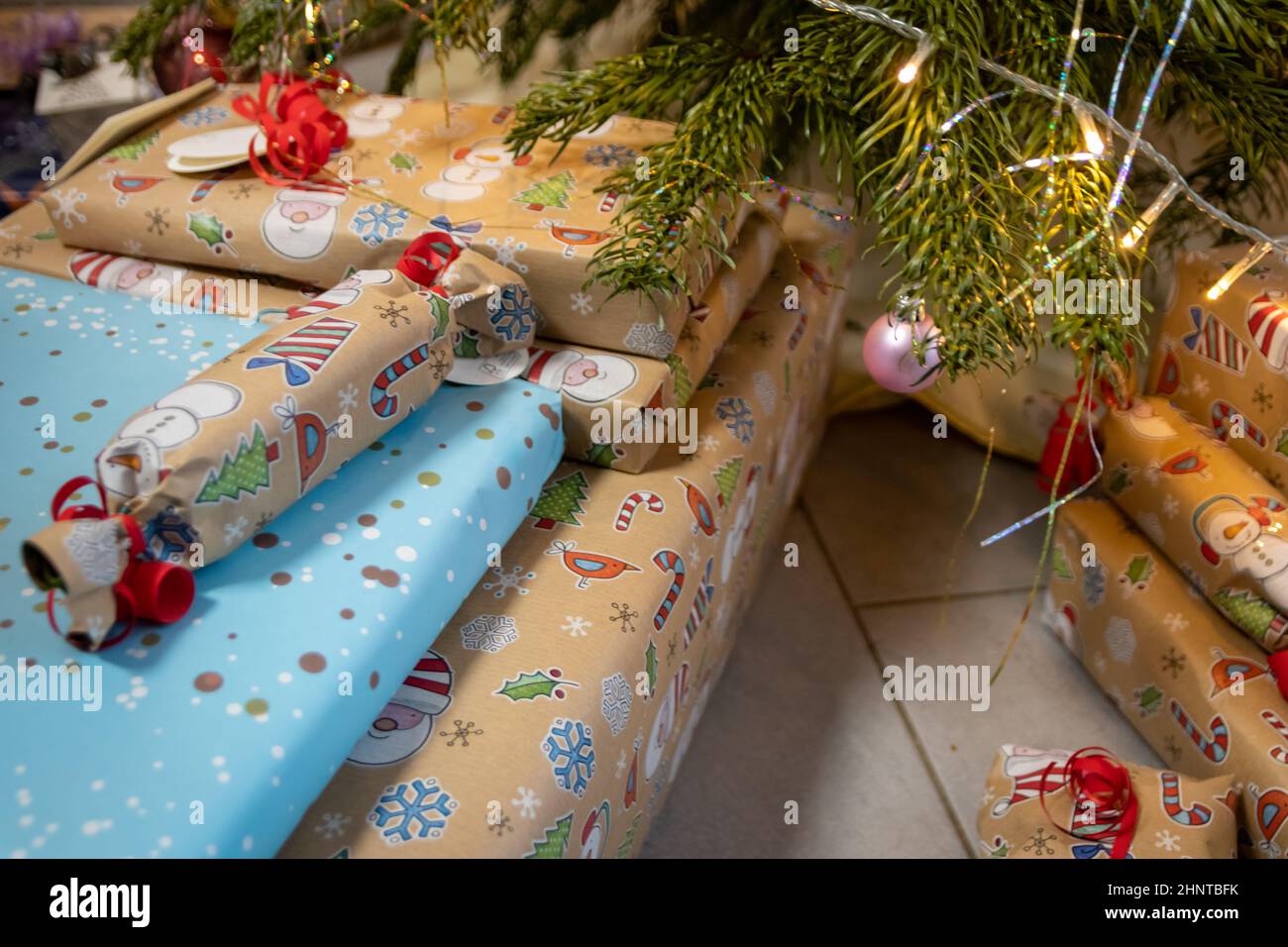 Cadeaux de Noël et cadeaux de Noël emballés sous l'arbre de Noël montrent un événement décoratif de unboxing avec célébration traditionnelle de la saison d'hiver faite à la main pour la beauté étincelante des yeux des enfants Banque D'Images