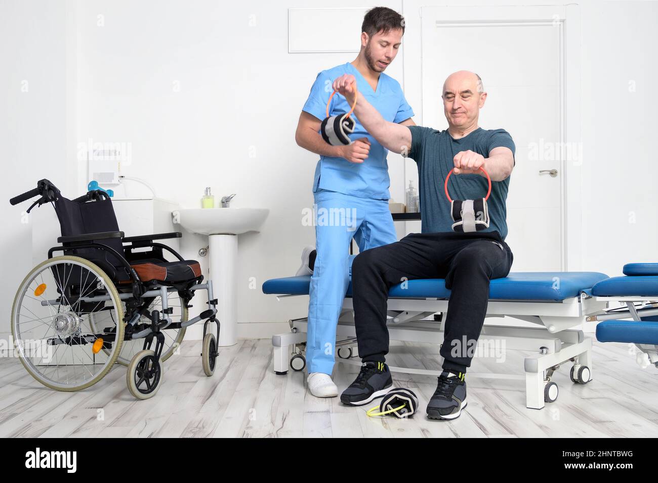 Homme handicapé faisant un exercice de récupération avec haltères. Homme avec Ataxy dans le système de soins de santé de physiothérapie de soutien de récupération. Banque D'Images